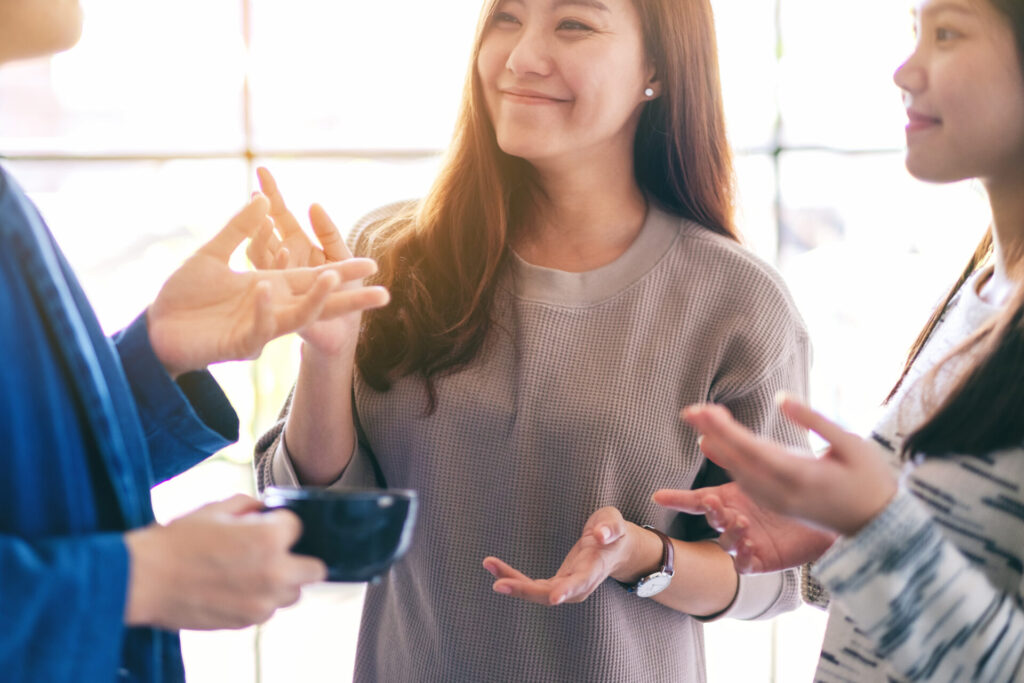 コーヒーを片手に会話を楽しむ友人たちの笑顔の様子